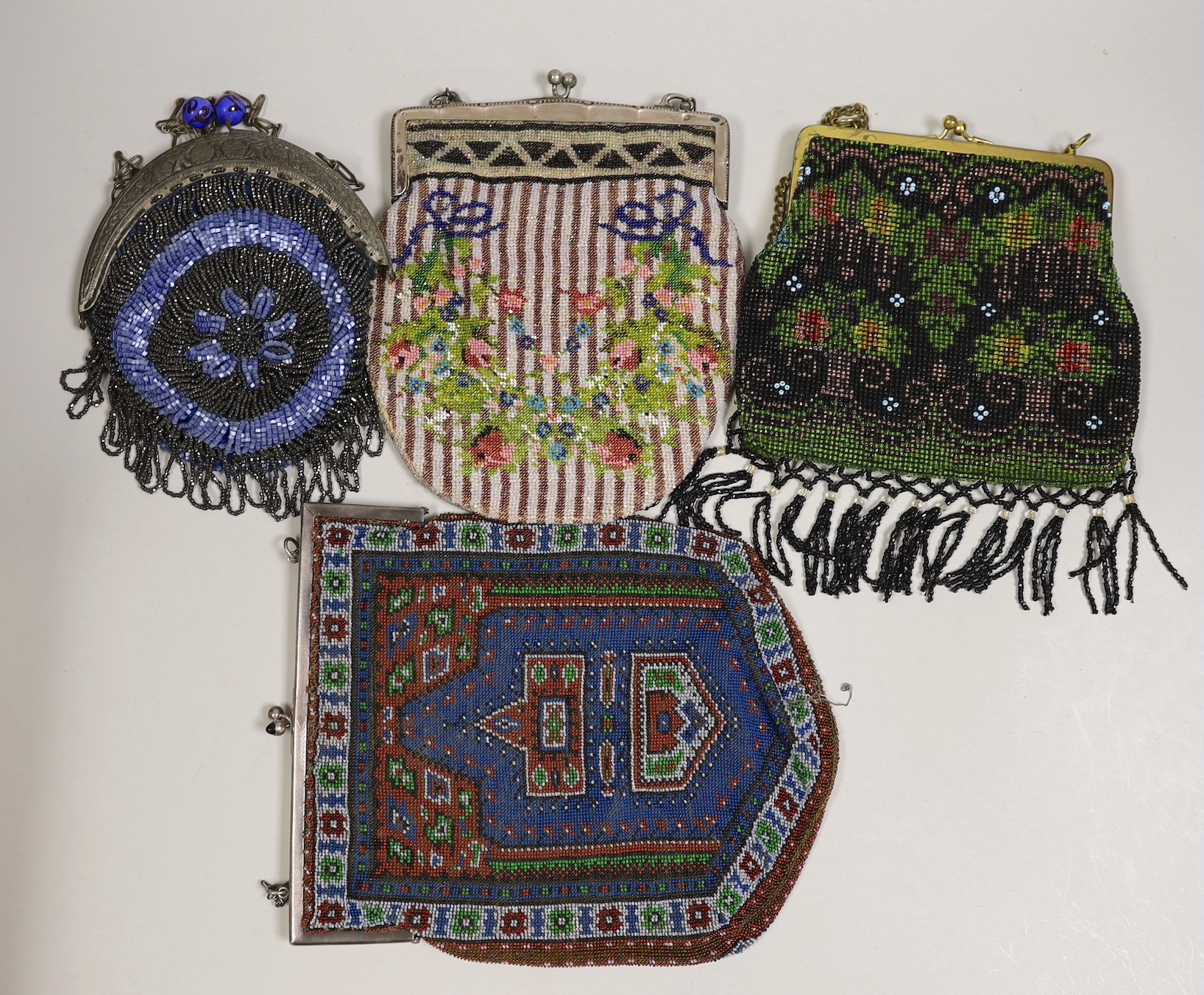 Two large metal framed Edwardian beaded bags, a later similar bead bag and a 1930’s metal framed bag with cut steel with blue beads.(4)